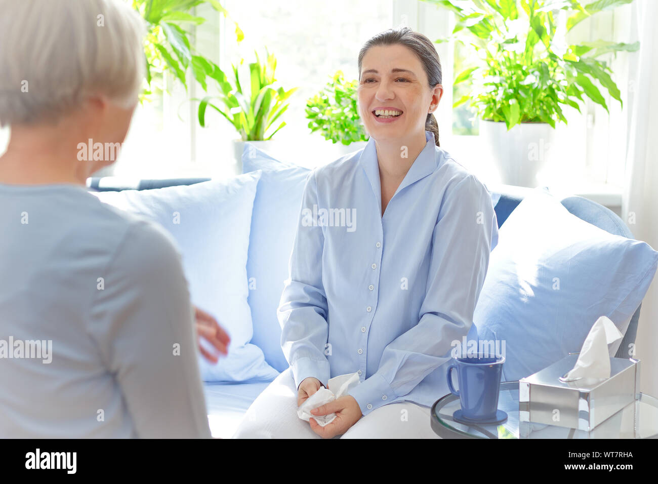 Positive Wirkung von Psychotherapie: Reifen Ratgeber Lachen mit ihrer glücklichen Patienten mittleren Alters. Stockfoto