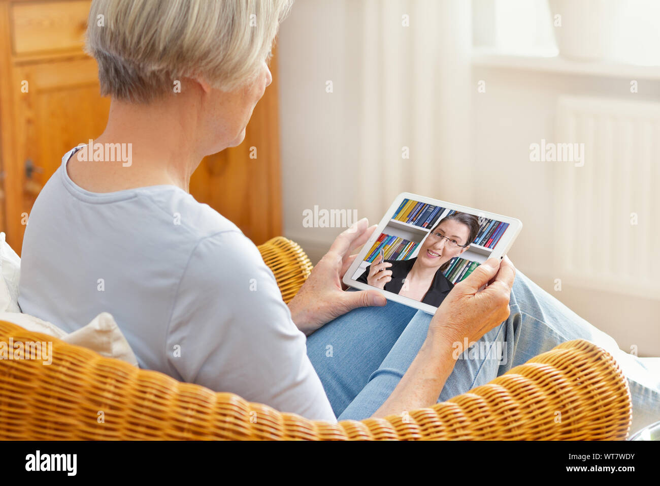 Teletherapie Konzept, ältere Frau im Gespräch mit Ihrem Berater oder Anwalt während eines Anrufs auf Ihrem Tablet-PC zu Hause Stockfoto