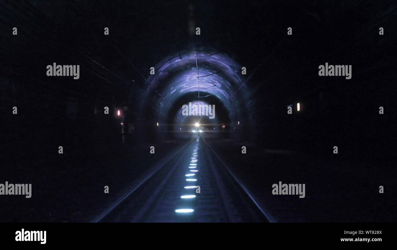 Helle zug Scheinwerfer in Richtung Kamera in einem dunklen Tunnel kommenden Stockfoto