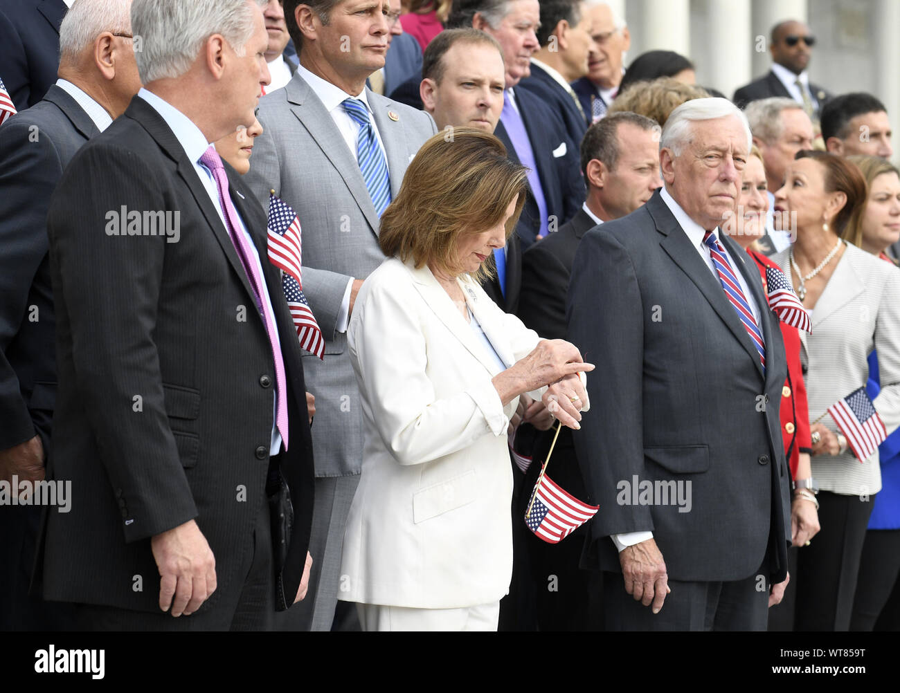 Sprecher Nancy Pelosi von Kalifornien (C) überprüft Ihr zusehen, wie sie und die Republikanische Führer Kevin McCarthy von Kalifornien (L) und Rep. Steny Hoyer (R) Mitglieder des Kongresses, auf den Stufen des US Capitol für eine Einhaltung der Anschläge des 11. September, 11. September 2019, in Washington, DC. Das Jubiläum ist jetzt ein Nationaler Tag des Dienstes und der Erinnerung. Foto von Mike Theiler/UPI Stockfoto