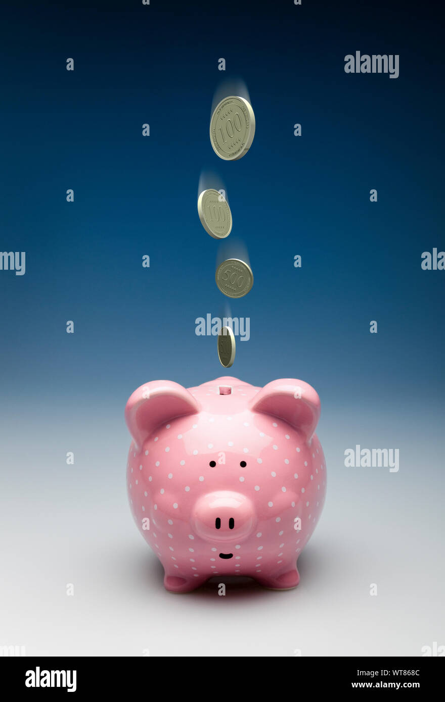 Rosa Sparschwein mit Gold Münzen fallen in es, Einsparungen oder Investitionen Konzept Stockfoto