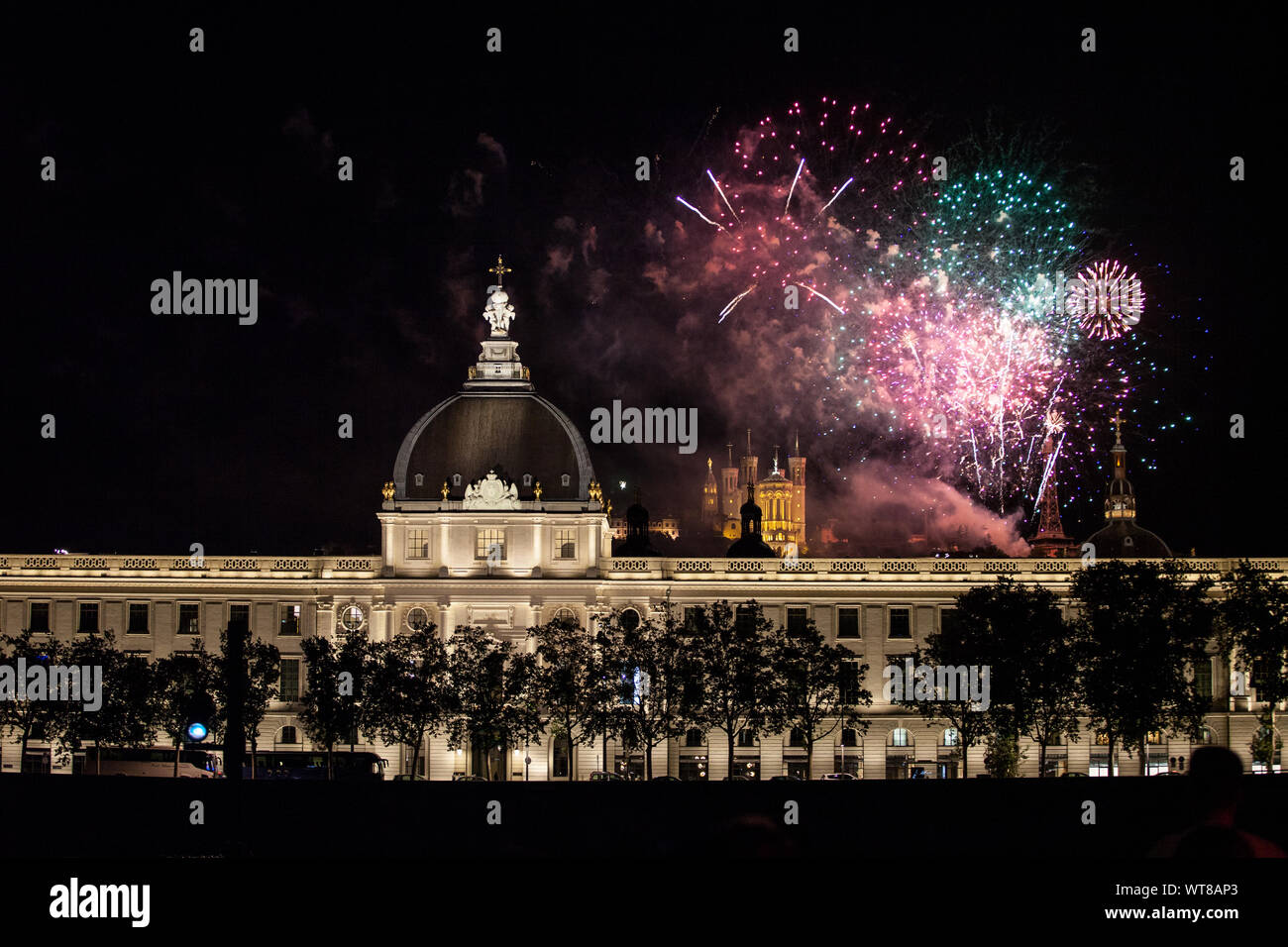 LYON, Frankreich - 14. JULI 2019: Feuerwerk platzen über Hotel Dieu in Lyon zum französischen Nationalfeiertag, Tag der Bastille, während die Basilique de Fourviere Basilikum Stockfoto