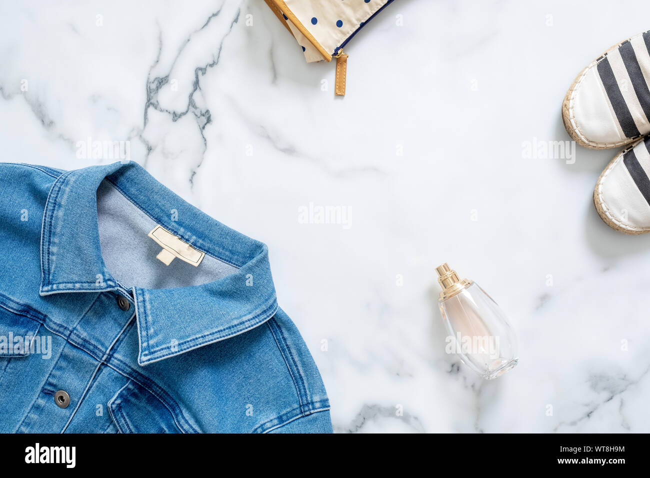 Schreibtisch der Schönheit Blogger mit feminine Jeans Jacke, Kosmetiktasche, Duft Flasche Parfüm, topmodische Sandalen. Retro altmodische Frauen clo Stockfoto