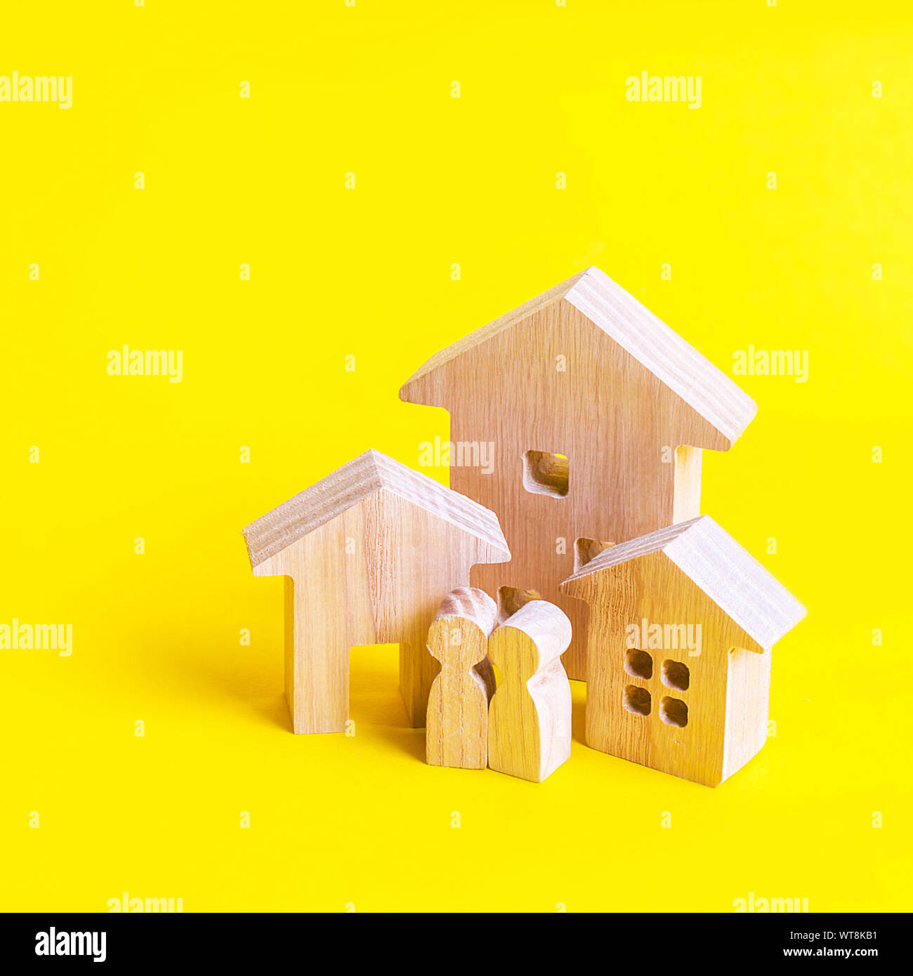 Drei Häuser und Menschen auf einem gelben Hintergrund. Kauf und Verkauf von Immobilien, Bau. Wohnungen und Wohngebäude in einer Stadt oder fest Stockfoto