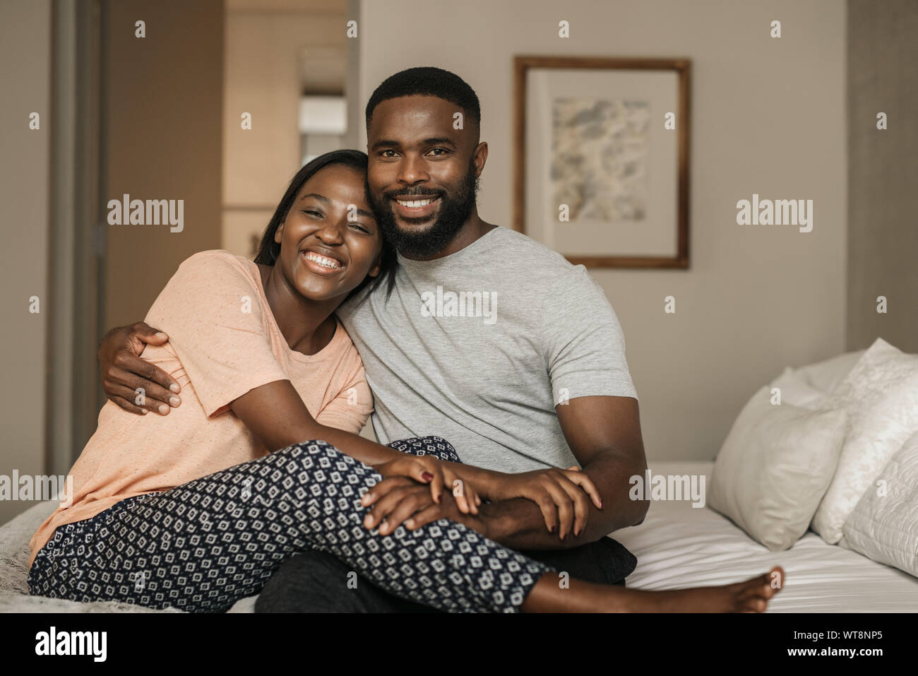 Afrikanische amerikanische Paar sitzt auf ihrem Bett am Morgen Stockfoto
