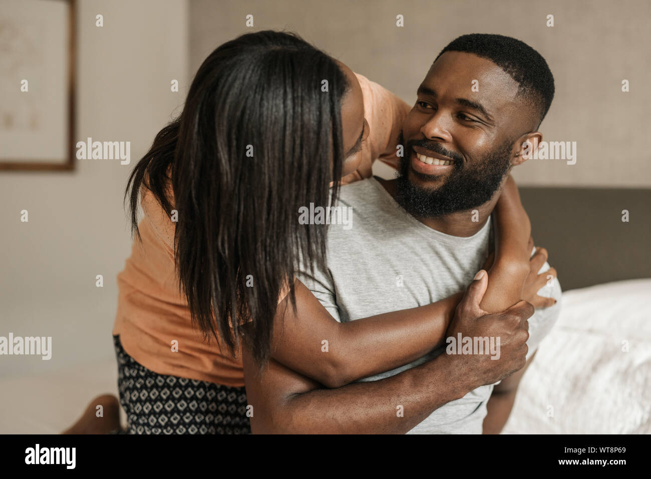 Herzlichen afrikanischen amerikanischen Paar sitzt auf ihrem Bett tragen Schlafanzug Stockfoto