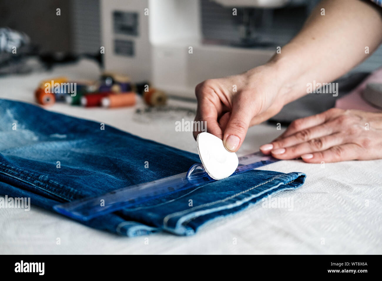 Näherin Kennzeichnung Saum auf ein Paar Jeans in Schneiderei Stockfoto