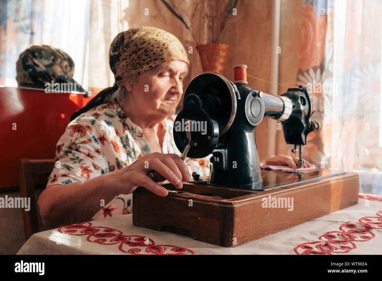 Closeup Porträt der alten Frau, die Nähmaschine, 70 Jahre Näherin arbeiten zu Hause Stockfoto