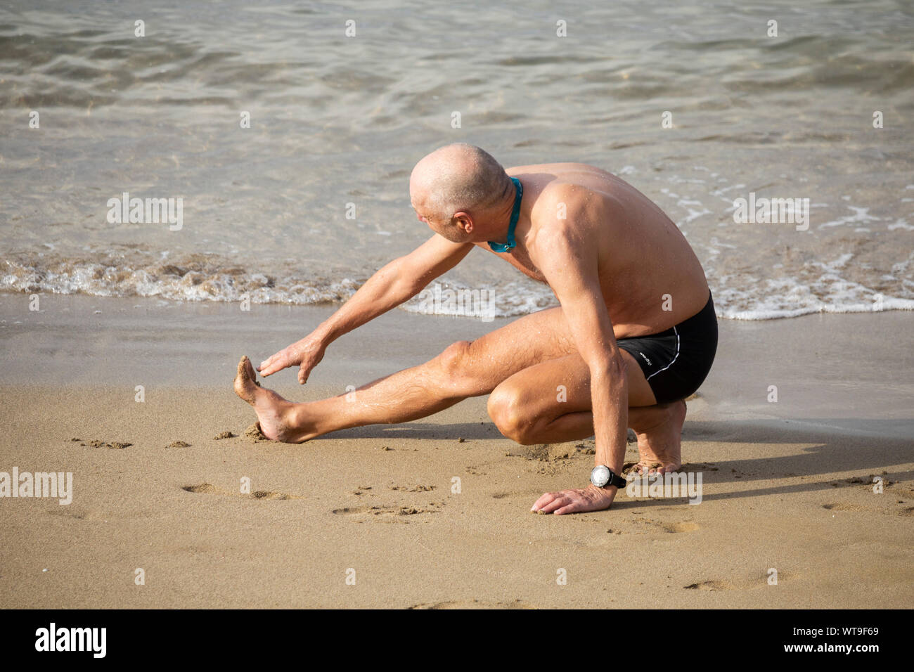 Ältere Menschen, die sich am Strand vor dem Schwimmen. Stockfoto