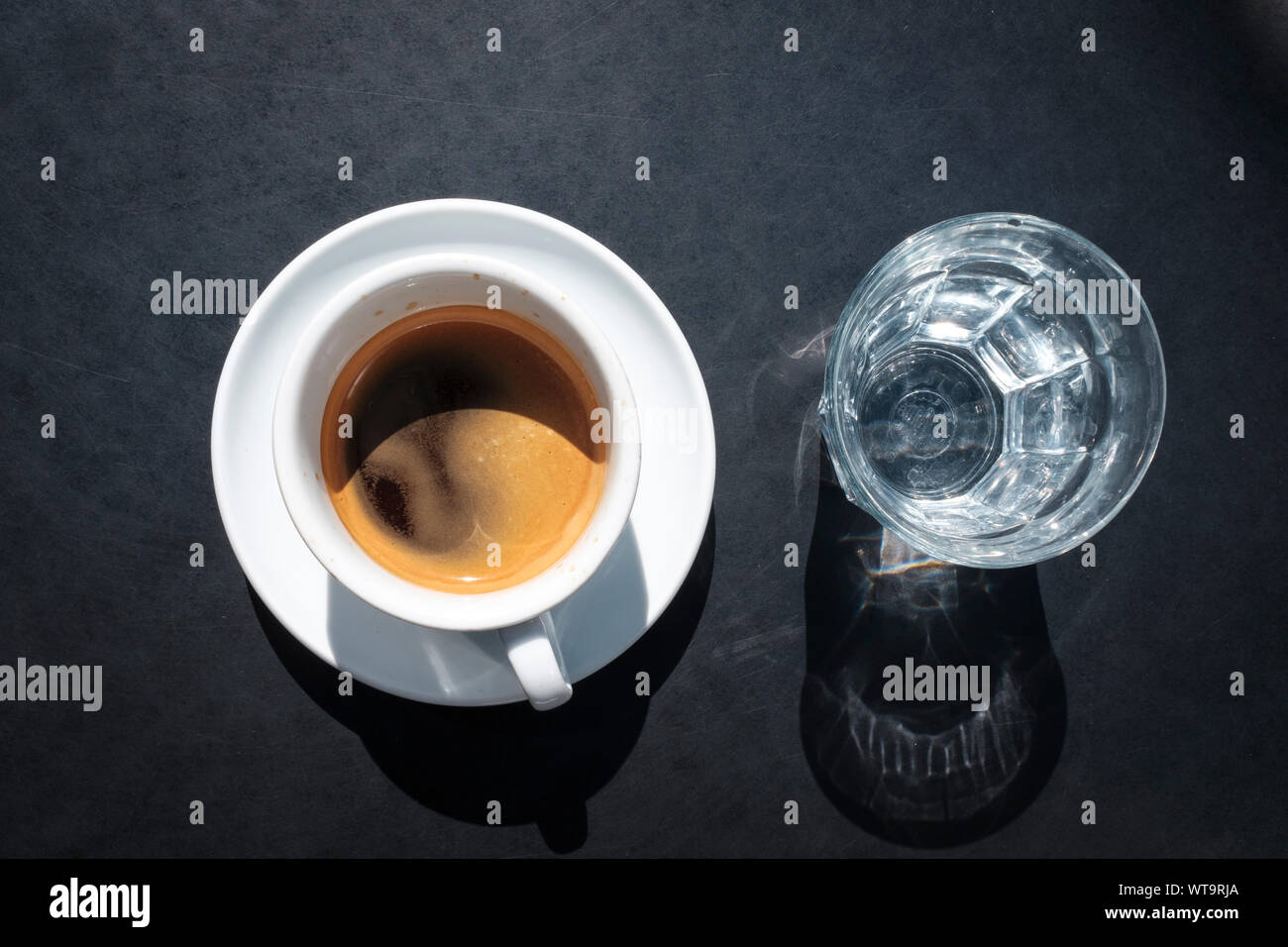 Doppelter Espresso und ein Glas Wasser auf dem Tisch oben, Ansicht von oben Stockfoto