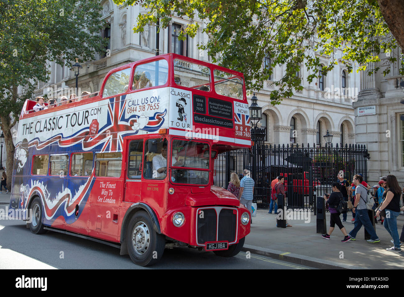 Alte Klassiker London Bus Symbol, hier als Tourist Bus verwendet, hält direkt vor dem berühmten Londoner Sehenswürdigkeiten 10 Downing Street, der Heimat der Premierminister Großbritanniens. Stockfoto