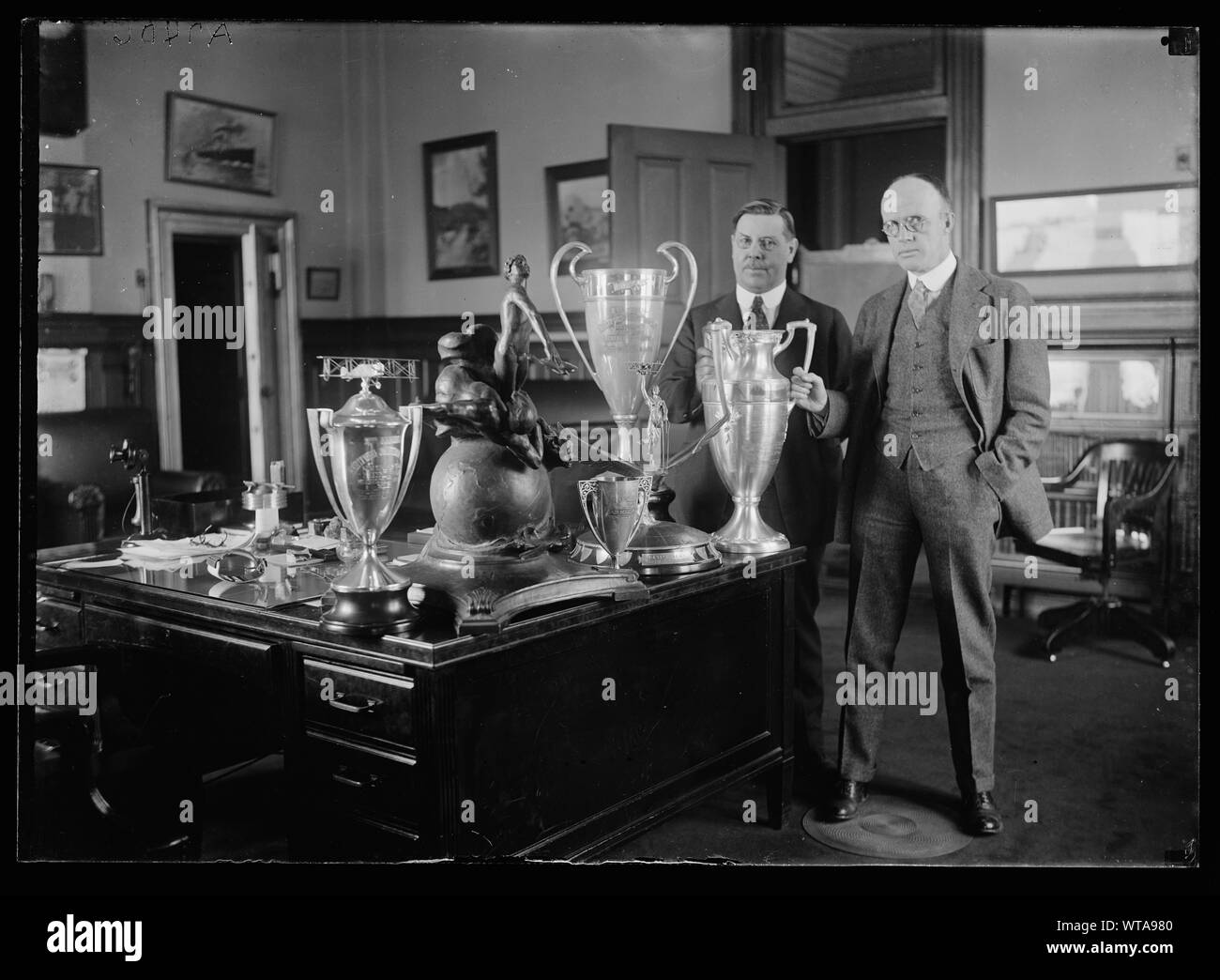 Männer mit Trophy Cups auf Schreibtisch Stockfoto