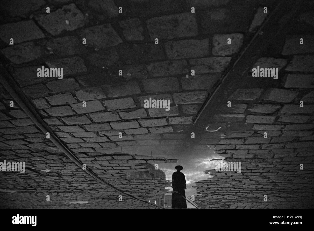 Priester, spiegelt sich in einer Pfütze in Salvador da Bahia Stockfoto