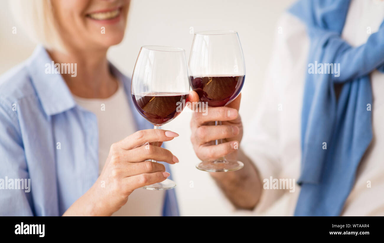 Reifes Paar klirren Gläser Rotwein Stockfoto