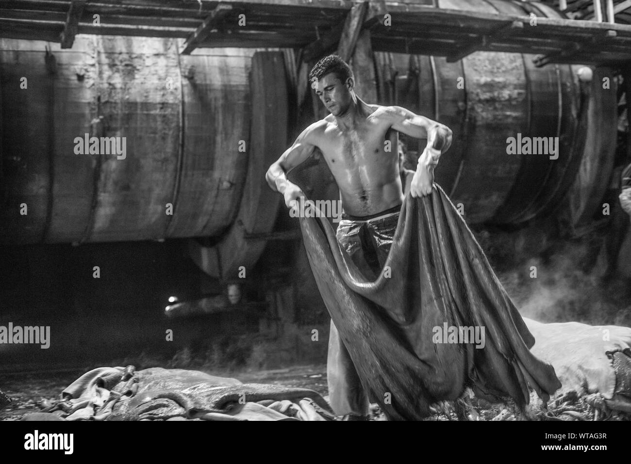 Starke Arbeiter Ziehen einer schweren Leder Stück in einer Gerberei Stockfoto