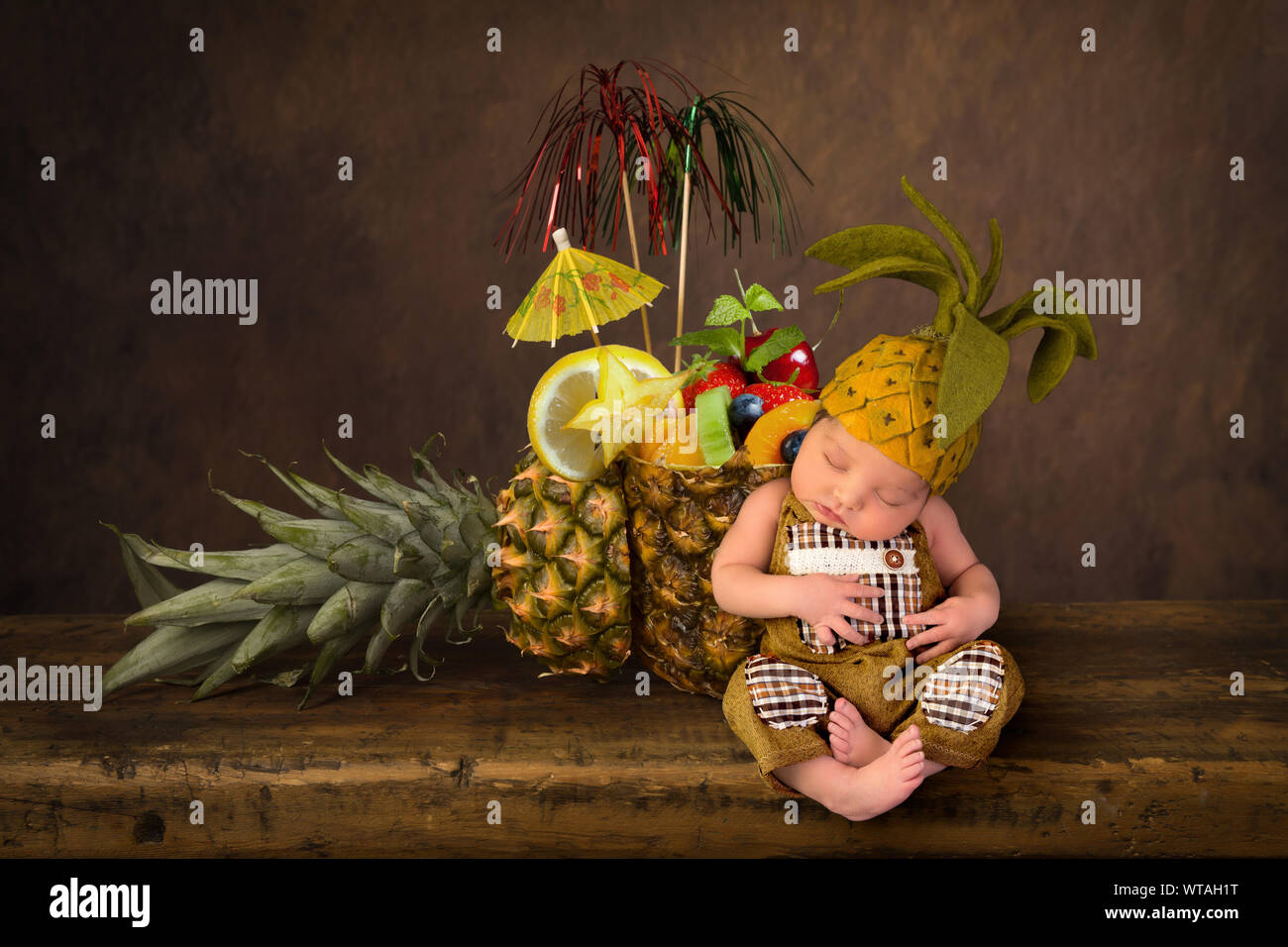 Cute zusammengesetztes Bild mit frischer Ananas und ein neugeborenes Baby in gefilzte Ananas hat Stockfoto
