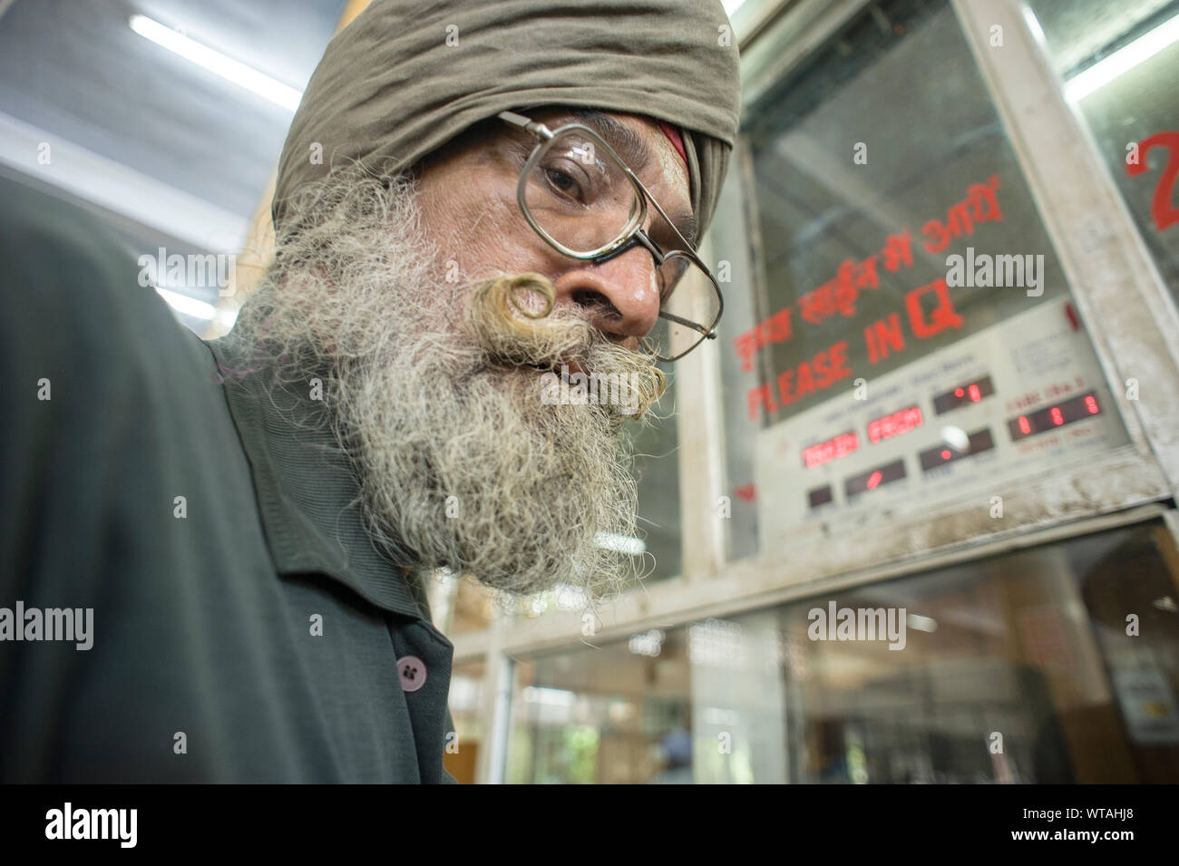 Sikh Mann mit dem großen Schnurrbart in den Bahnhof Ticket Office Stockfoto
