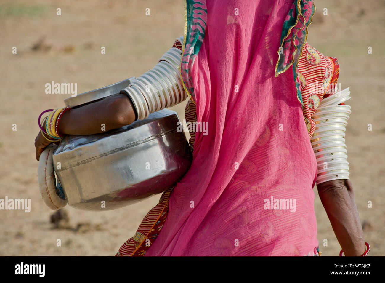 Rajasthani Frau, der einen Krug in der Wüste Thar Stockfoto