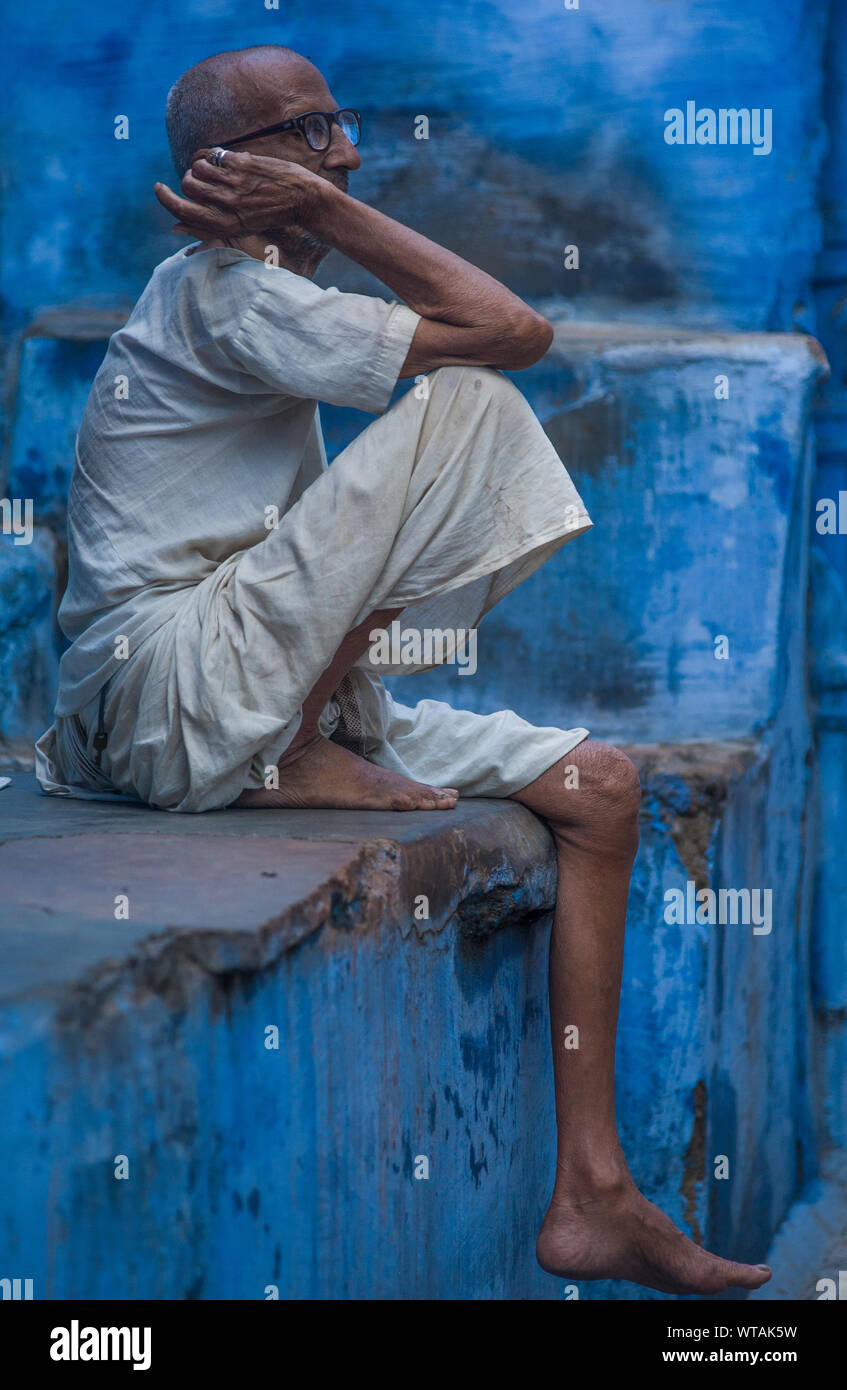 Alter Mann in traditioneller Kleidung Sitzgelegenheiten rund um Indigo Blue Häuser Stockfoto