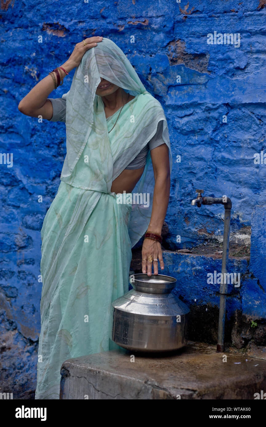 Rajasthan Frau Sari Fänge Wasser in einem Wasserhahn Stockfoto