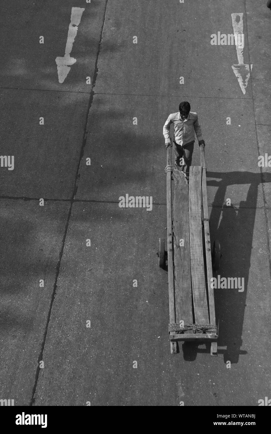 Luftaufnahme eines Arbeitnehmers mit einer Holz- hand-Lkw auf der Straße Stockfoto