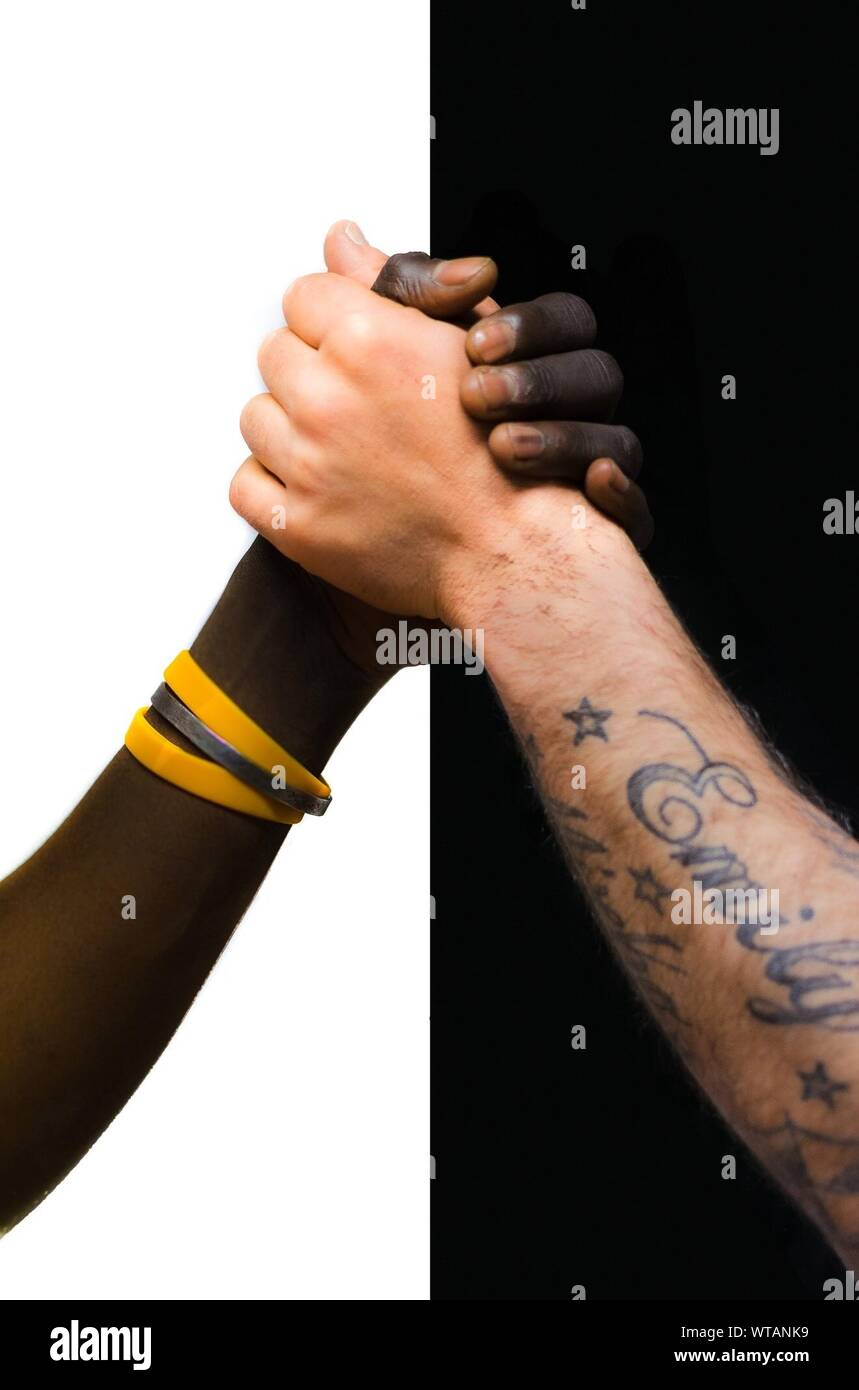 Zugeschnittenes Bild der multi-ethnischen Menschen halten sich an den Händen Stockfoto