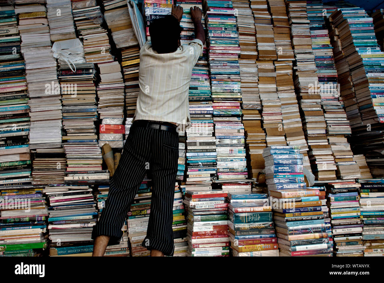 Man organisiert einen gebrauchten Buchhandlung Stockfoto