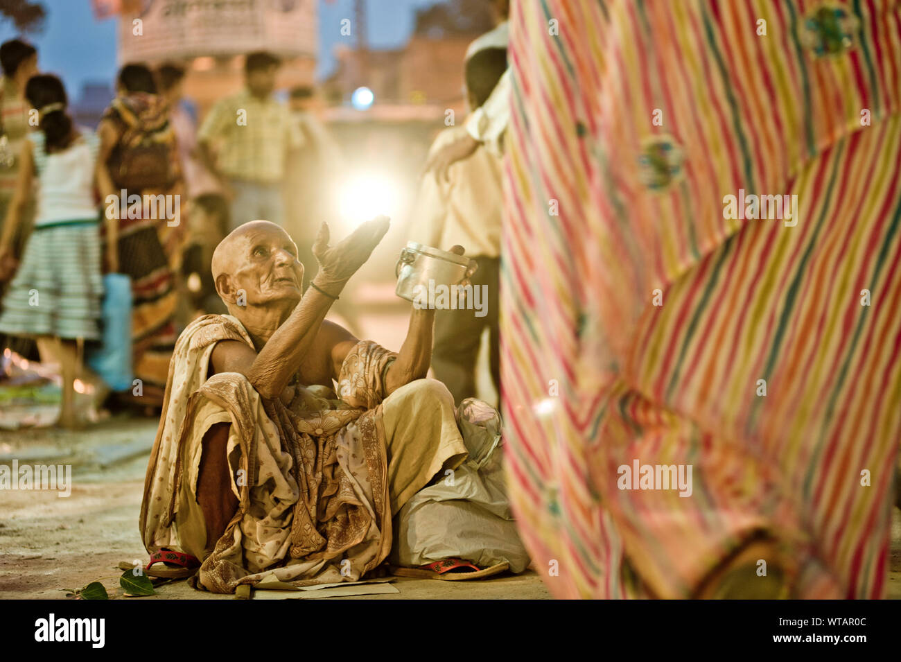 Alte Frau in den Straßen von Varanasi betteln Stockfoto