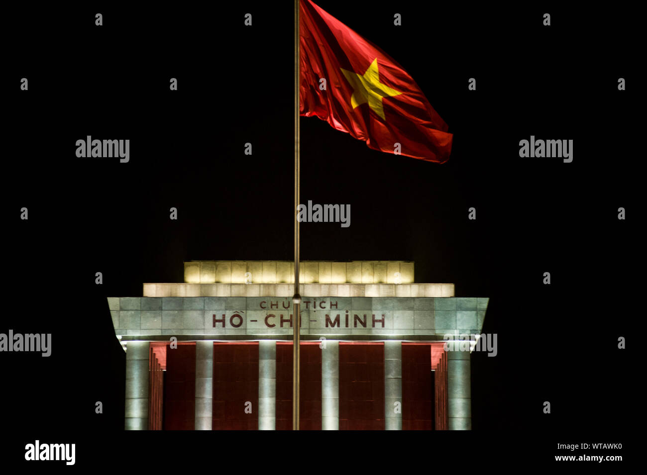 Ho Chi Minh Mausoleum in der Nacht und Vietnam Fahne im Wind flattern Stockfoto