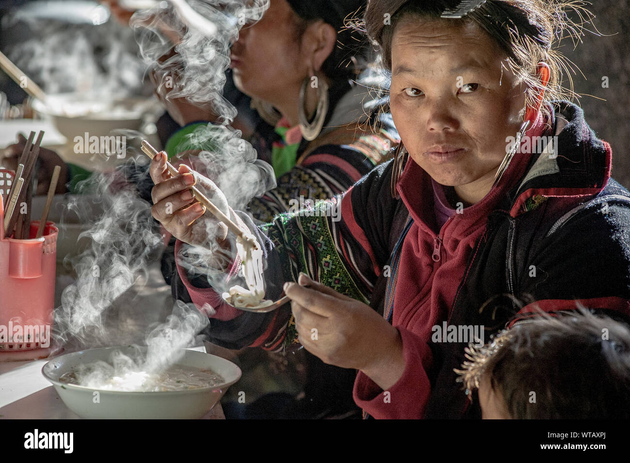 Hmong tribal Frau essen dampfenden Nudeln Suppe Stockfoto