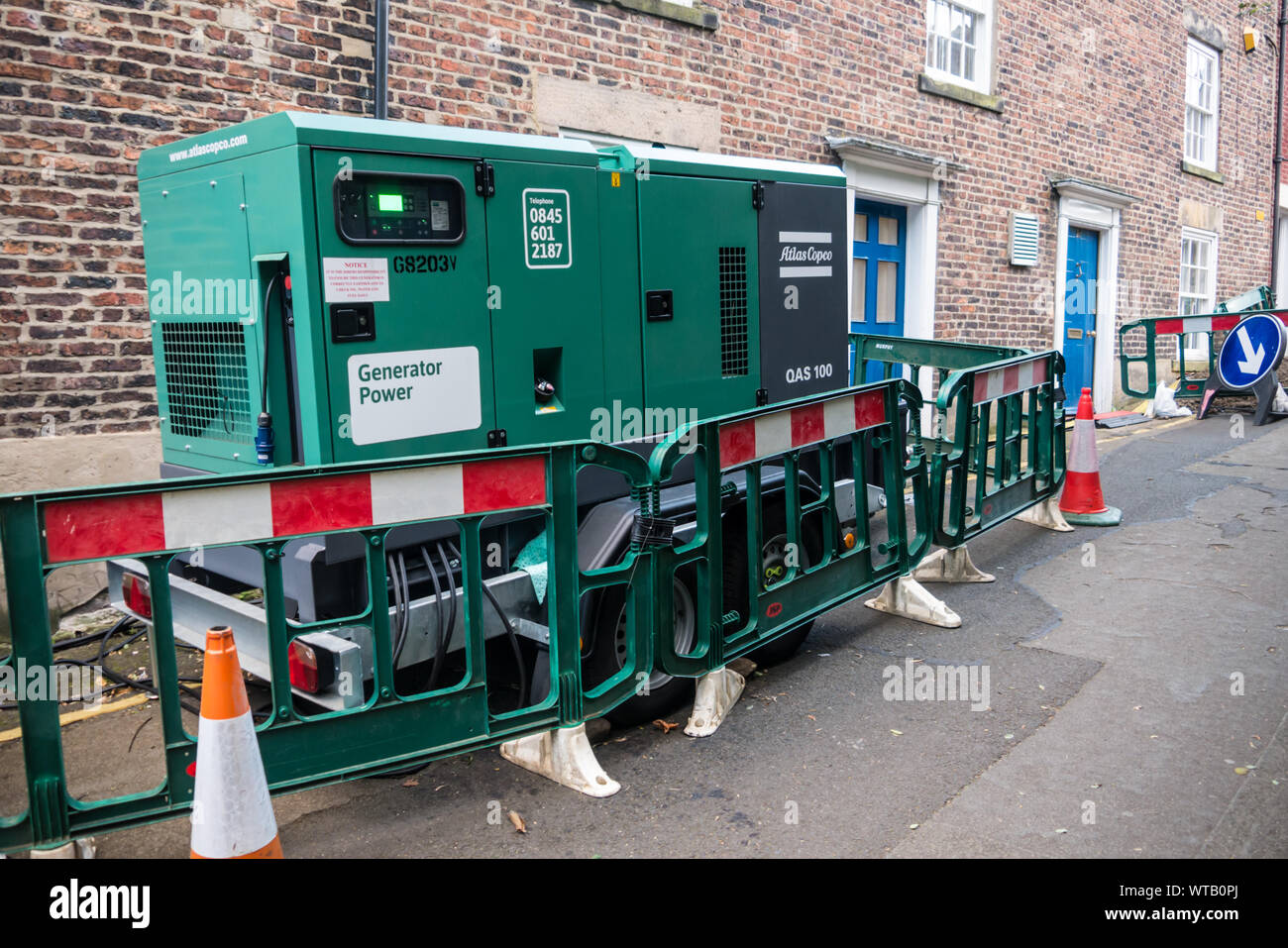 Ein Stromgenerator In einer BRITISCHEN Street bietet Notstrom Wohnhäuser Stockfoto