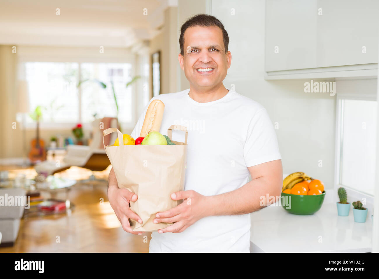 Mittleres alter Mann mit grocieries Beutel voller Gemüse zu Hause Stockfoto