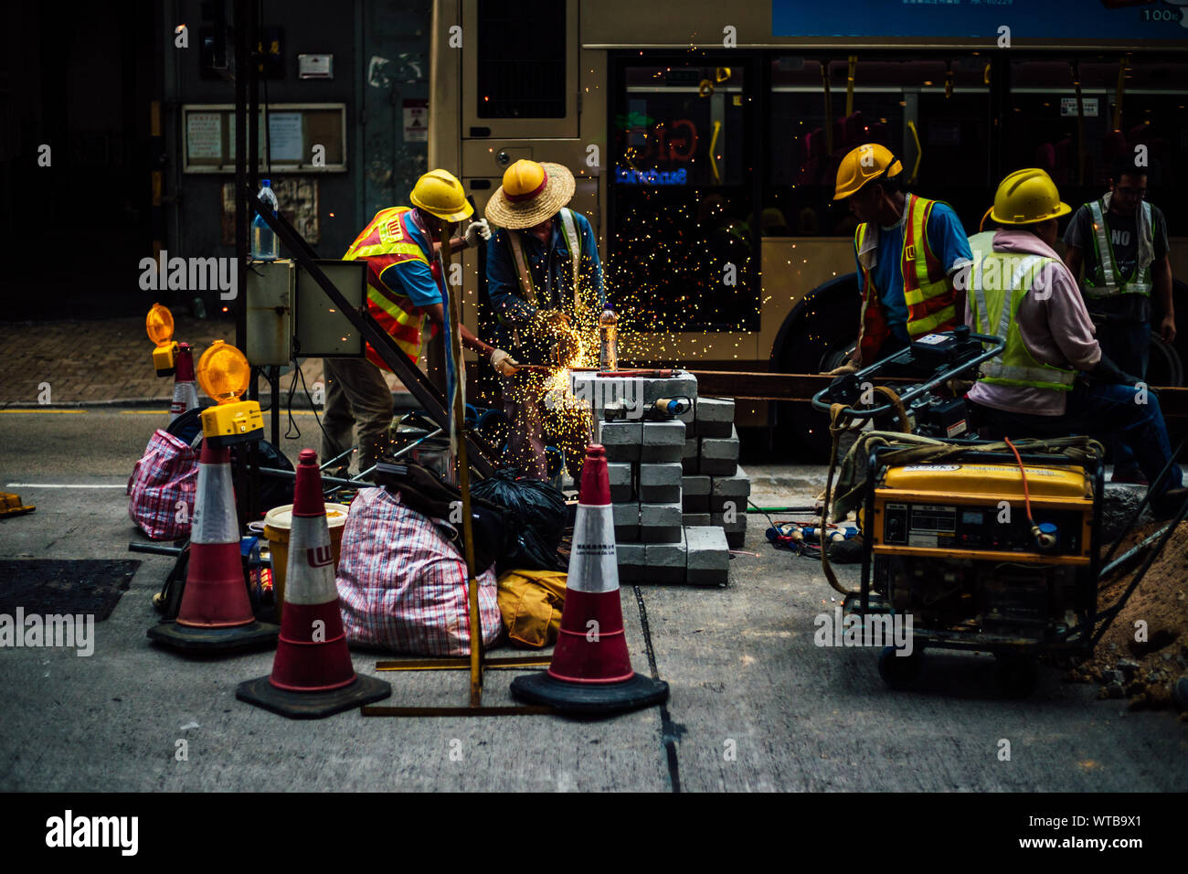 Arbeiter arbeiten auf Straße gegen Bus Stockfoto