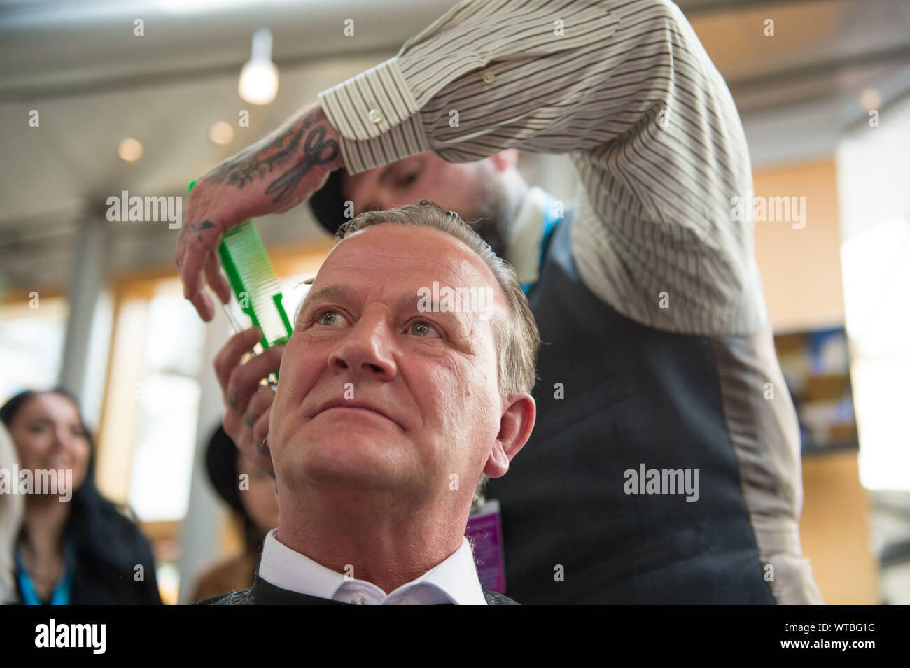 Edinburgh, Großbritannien. 5. September 2019. Bild: David Torrance MSP-Kirlcaldy der Vertreter für die Scottish National Party, erhält ein Haarschnitt im Stuhl des Barbour, "Chop Das Mop' für Maggies Krebs Liebe. Colin Fisher/CDFIMAGES.COM Stockfoto