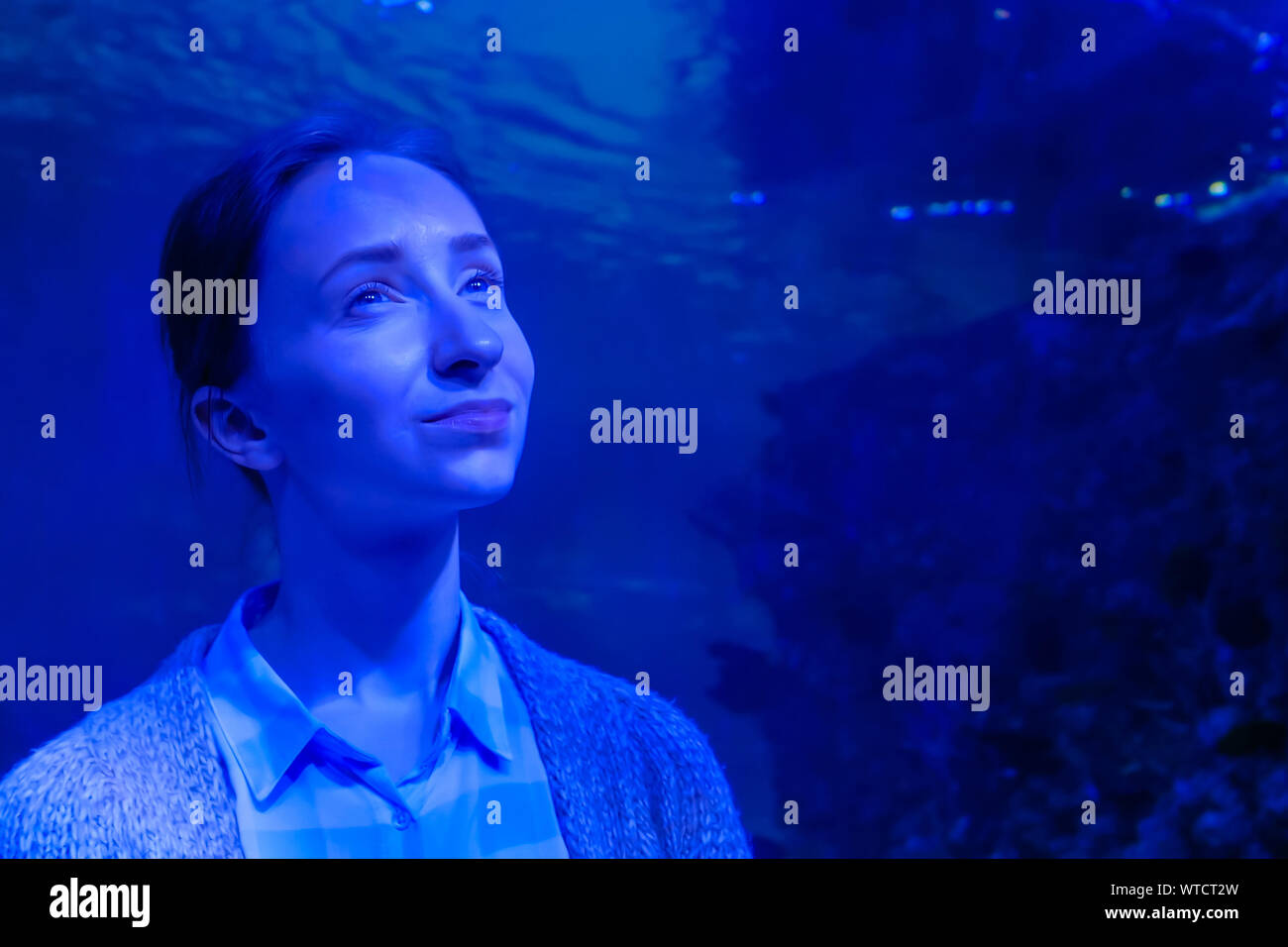 Frau auf der Suche nach Fisch in großen öffentlichen Aquarium Tank Oceanarium Stockfoto