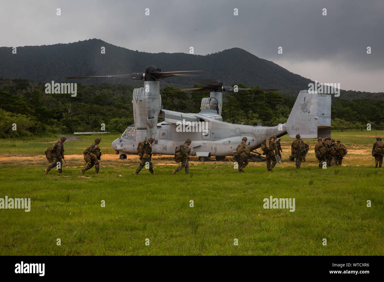 Marines mit Echo Company, Bataillon Landung Team, 2.BATAILLON, 1 Marines, 31 Marine Expeditionary Unit, Last auf einer MV-22 B Osprey Kipprotor-flugzeug nach einer langen Reihe von raid im zentralen Bereich Schulungen, Okinawa, Japan, August 14, 2019. Die 31. MEU und amphibische Squadron 11, an Bord der Wasp Amphibious Ready Gruppe Schiffe, führte eine Reihe von sequentiellen Operationen, die simulierten naval Expeditionary kombiniert - arme Manöver von Amphibischen Vermögenswerte zum Ufer, wobei Marine Air-Ground Task Force Fähigkeiten über alle warfighting Domänen integriert. (U.S. Marine Corps Foto von Lance Cpl. Kenny Stockfoto