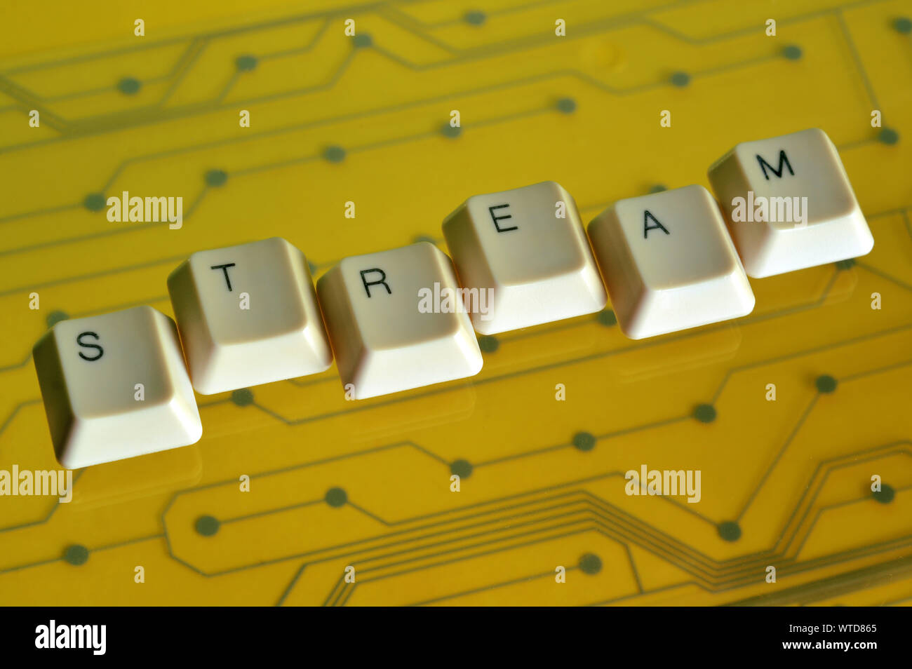 Die Tasten der Tastatur Form das Wort stream auf gelben Stromkreis im Hintergrund. Stockfoto