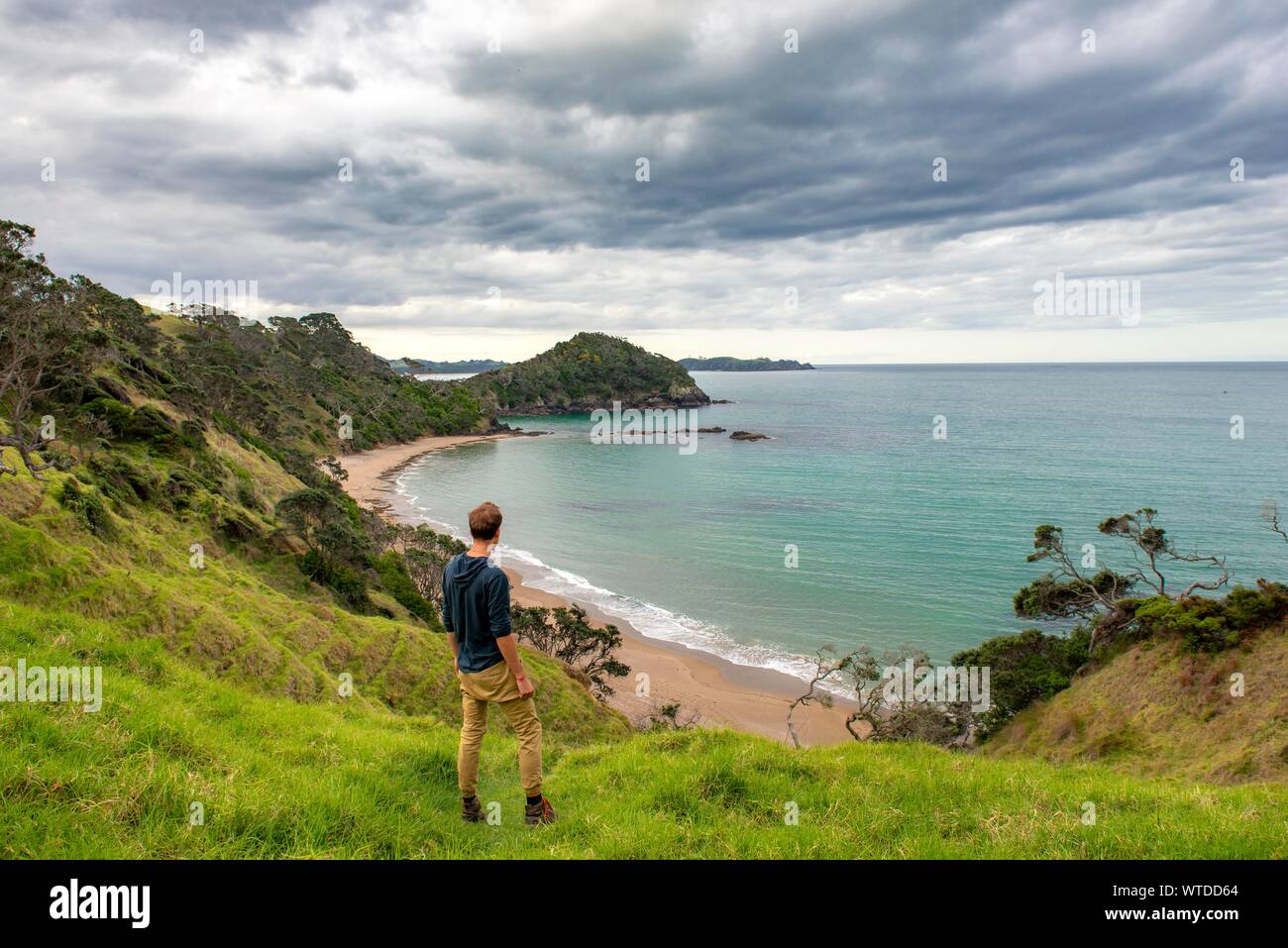 Junge Menschen über die Bucht, den Strand und die Bucht Daisy Bay, Northland, North Island, Neuseeland suchen Stockfoto