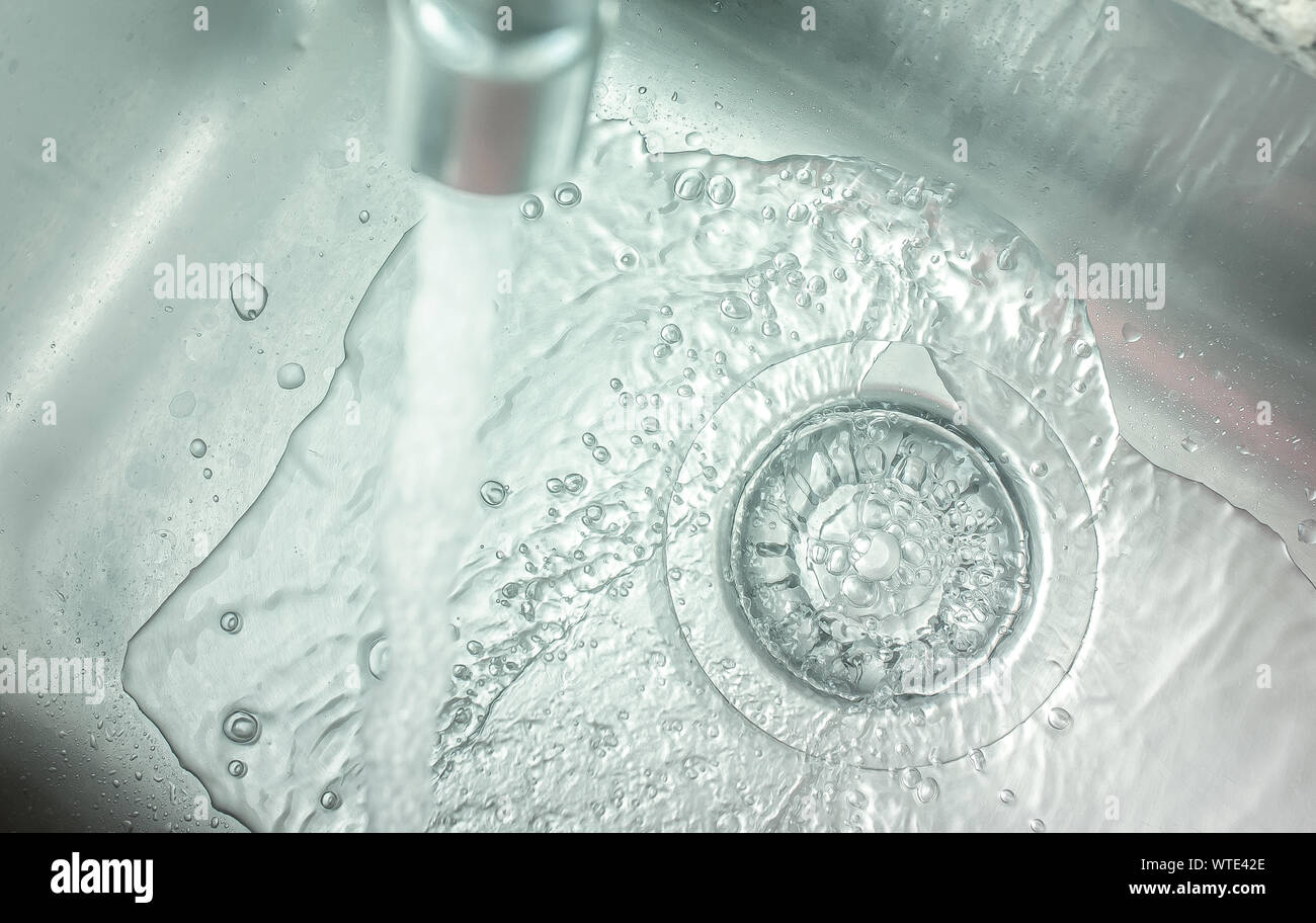 Tippen Sie auf "Öffnen" gießt Wasser in das Waschbecken. Stockfoto