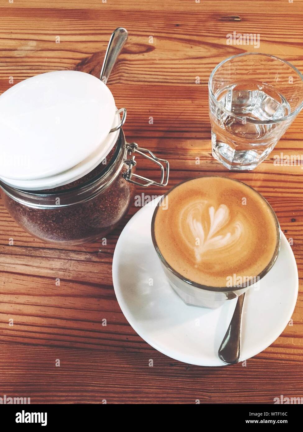 Kaffee mit Zucker und Wasser Glas auf dem Tisch Stockfoto