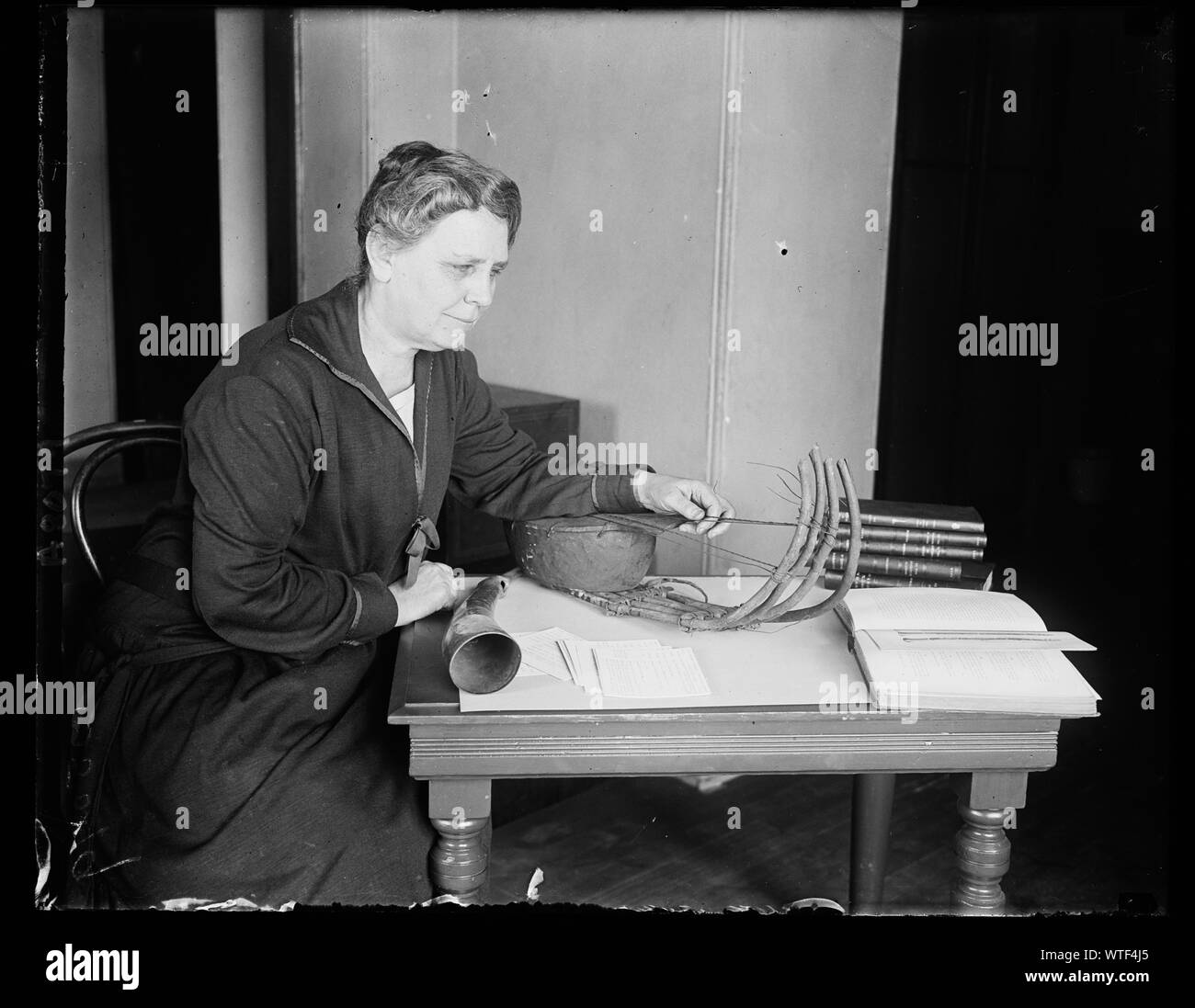 Miss Frances Densmore, Experte in der indischen Musik, die für das Personal der Nat'l Museum in Washington hinzugefügt wurde, sie war früher mit der Amer verbunden. Büro der Ethnologie, das Smithsonian. Sie ist jetzt in der einzigartigen Sammlung von Musikinstrumenten aus allen Ländern, die gesammelt und im Museum. Hier zeigt mit 2 der ältesten Musikinstrumente der Inder, einer alten Geige und einer Horn von Elephant Tusk gemacht Stockfoto