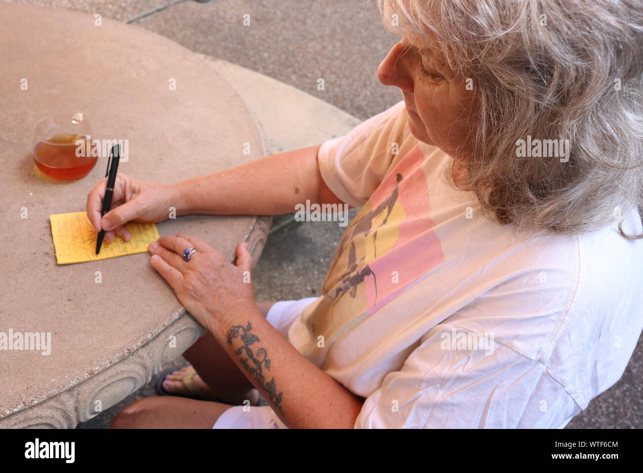 Ältere Frau Schreiben einer Notiz Stockfoto