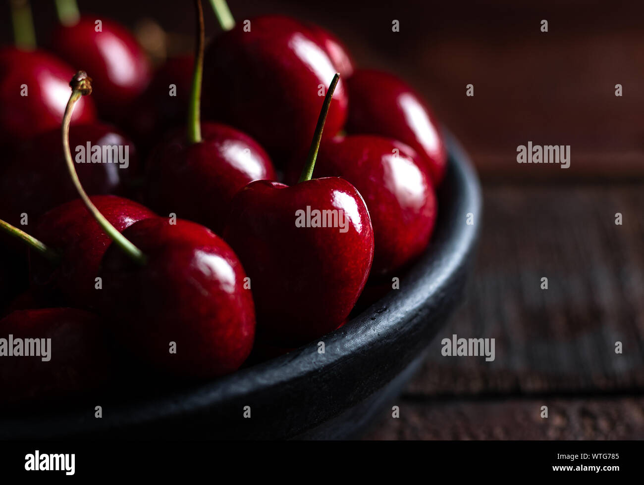 In der Nähe von Pile von reifen Kirschen mit Stängeln. Große Sammlung von frischen roten Kirschen. Reifen Kirschen Hintergrund. Stockfoto