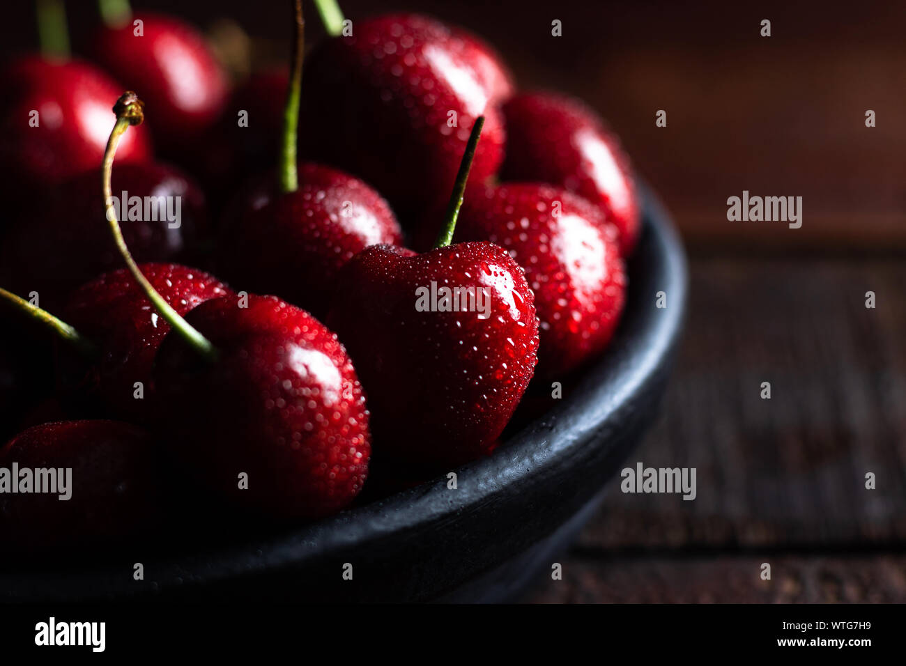 In der Nähe von Pile von reifen Kirschen mit Stängeln. Große Sammlung von frischen roten Kirschen. Reifen Kirschen Hintergrund. Stockfoto