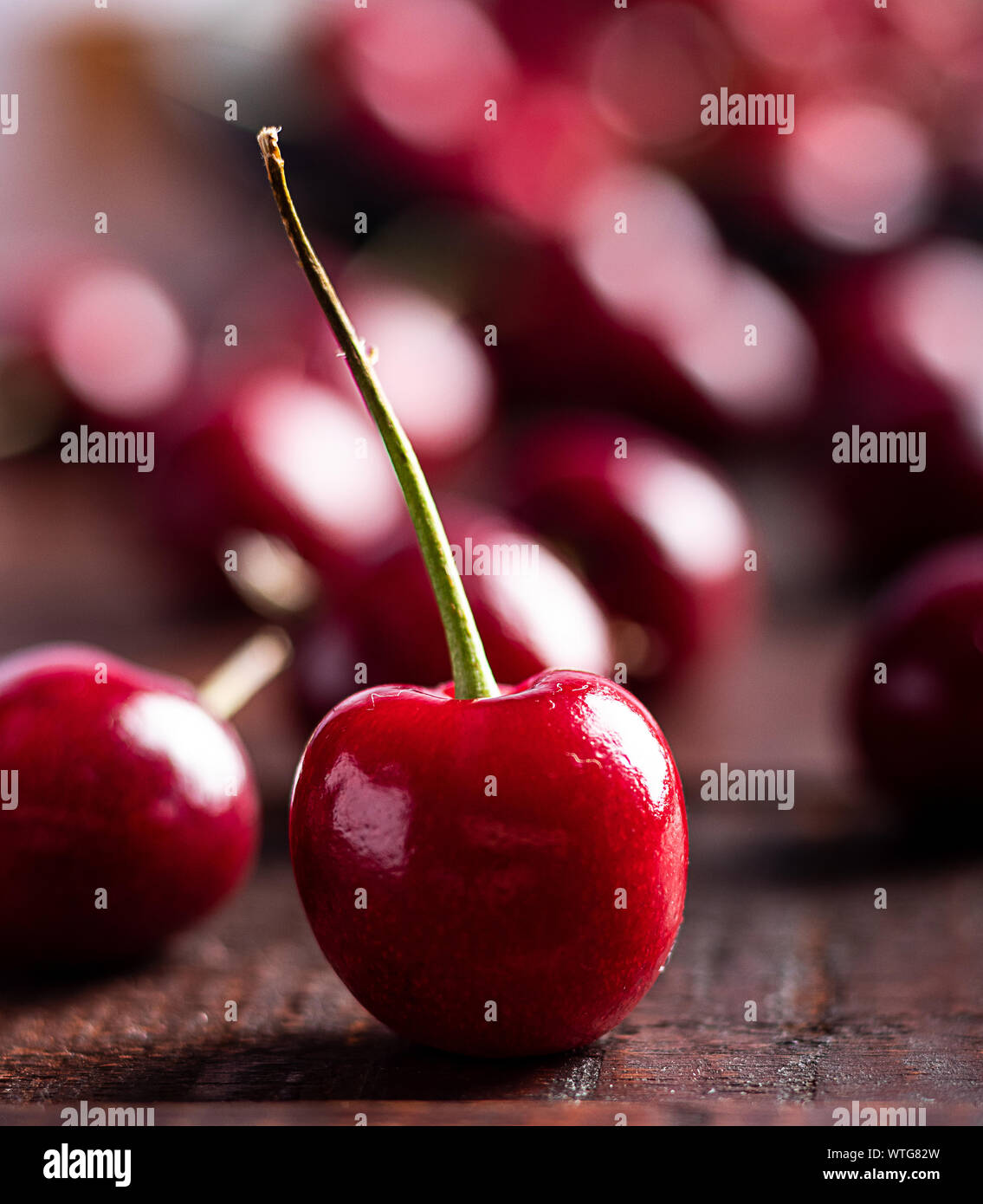 In der Nähe von Pile von reifen Kirschen mit Stängeln. Große Sammlung von frischen roten Kirschen. Reifen Kirschen Hintergrund. Stockfoto
