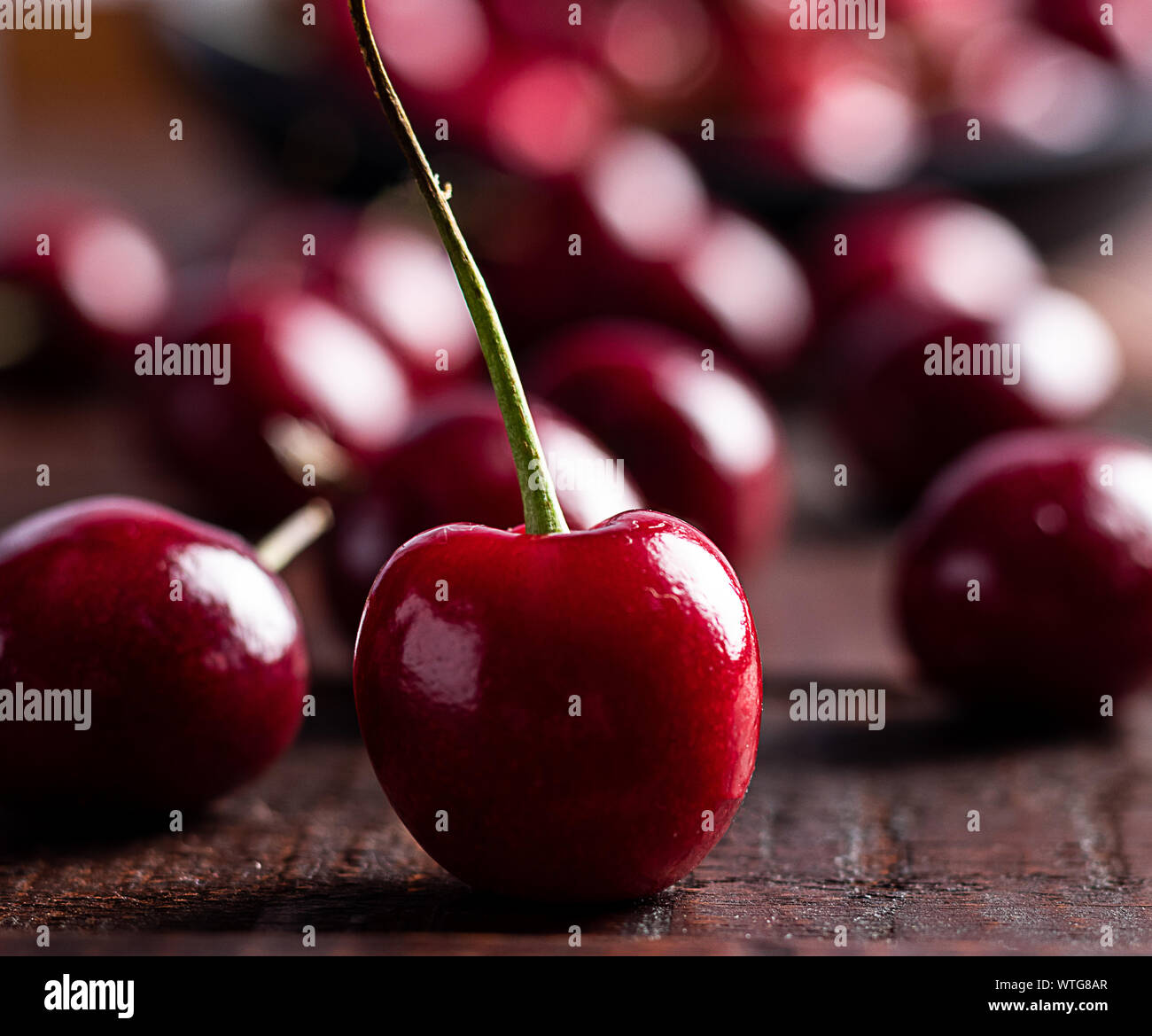 In der Nähe von Pile von reifen Kirschen mit Stängeln. Große Sammlung von frischen roten Kirschen. Reifen Kirschen Hintergrund. Stockfoto