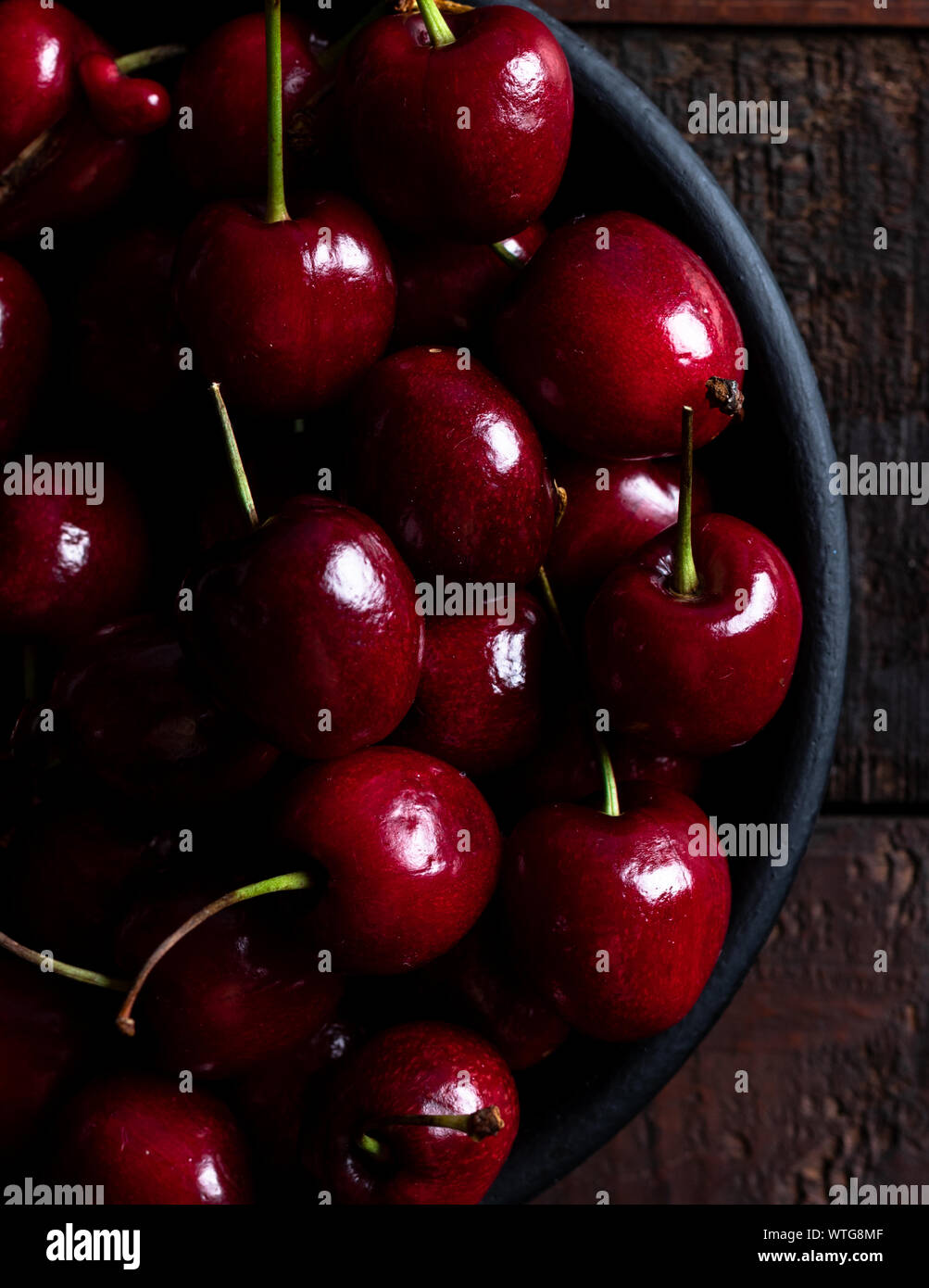 In der Nähe von Pile von reifen Kirschen mit Stängeln. Große Sammlung von frischen roten Kirschen. Reifen Kirschen Hintergrund. Stockfoto