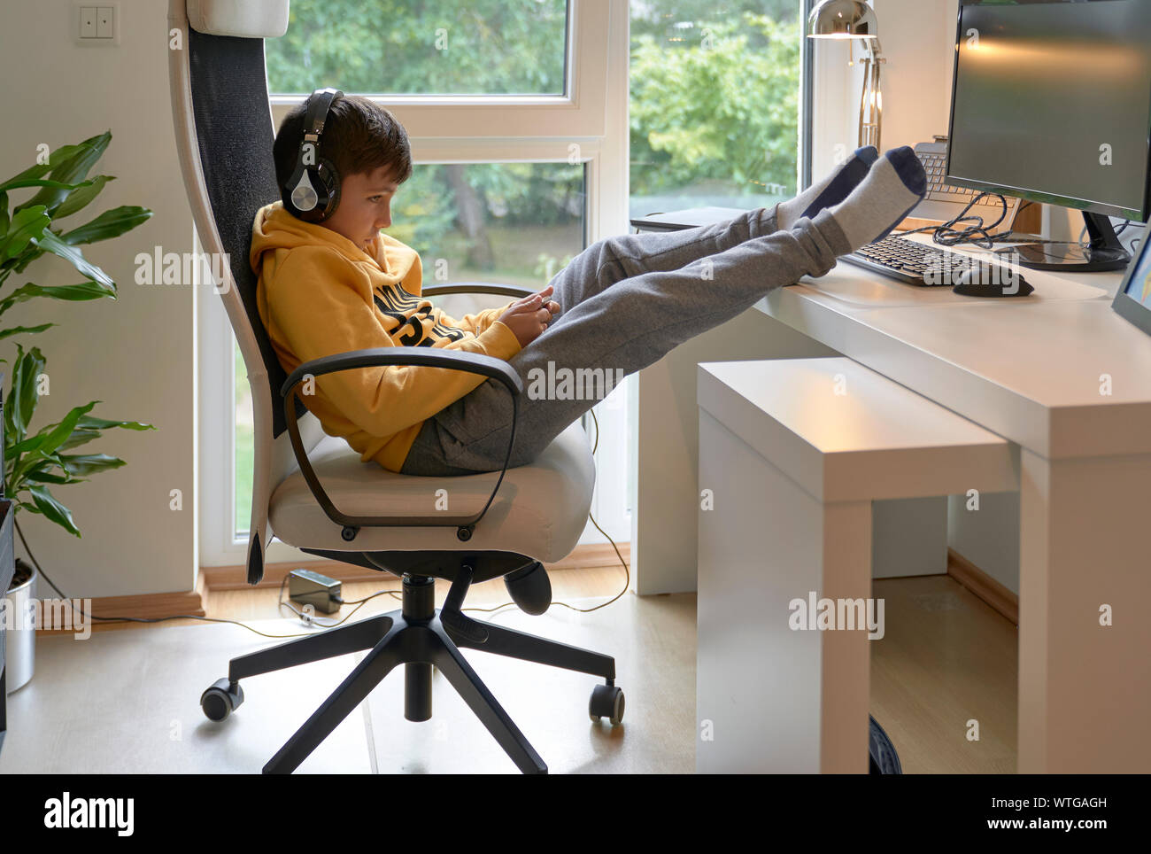 Kind mit seinem Handy im Büro Stockfoto
