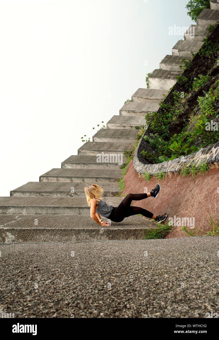 Frau scheint wie ein Sturz auf Beton Boden. Optische Illusion mit gezwungen Perspektive Technik. Espacio Escultórico, UNAM, Mexiko City, Mexiko. Stockfoto