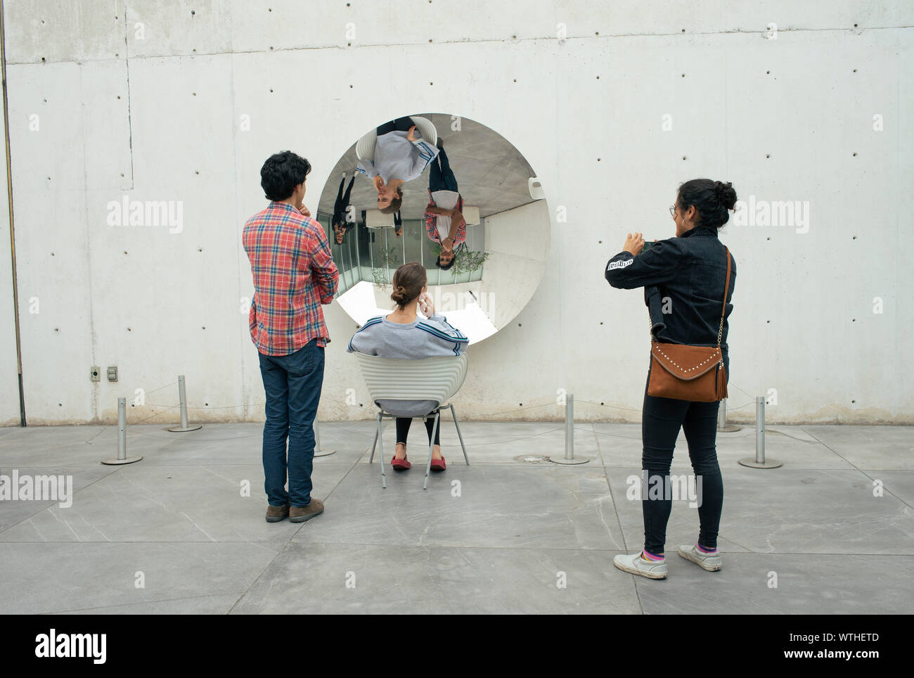 Junge Studenten interagieren mit Teller Spiegel artwork Installation von Anish Kapoor. University Museum Moderner Kunst, Mexico City, CDMX, Mexiko. Jun 2019 Stockfoto